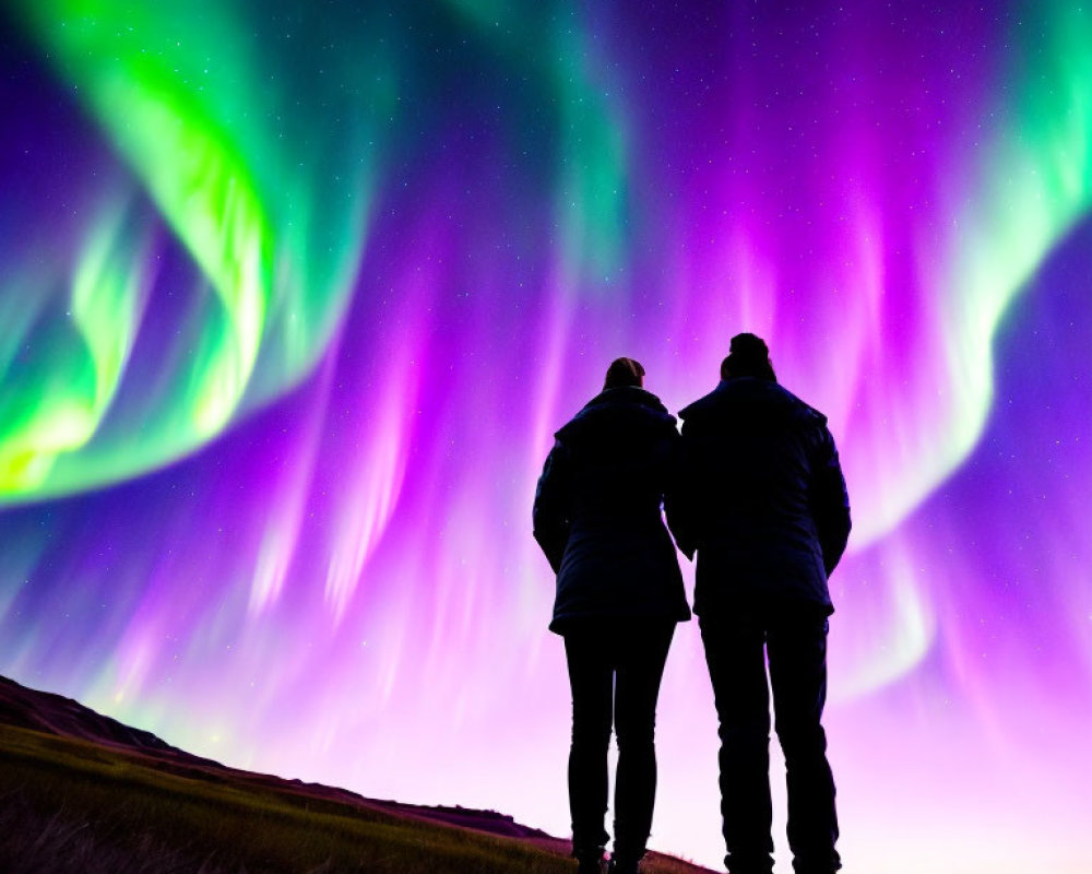 Silhouetted couple under vibrant aurora borealis