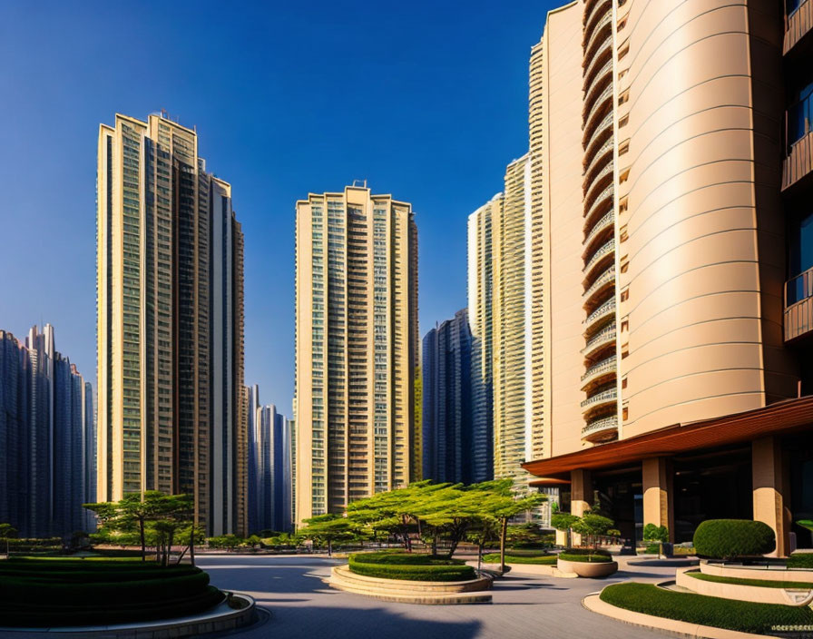 Urban high-rise buildings overlooking landscaped courtyard with green trees under blue sky