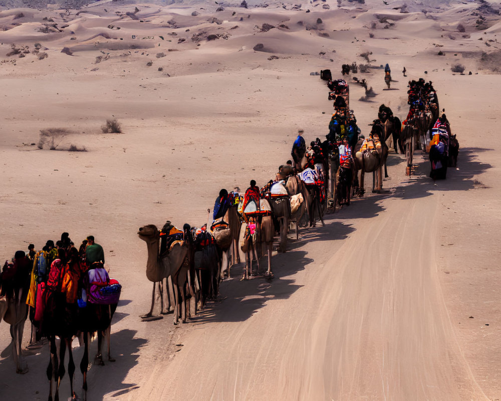 Camel caravan with riders crossing sandy desert trail