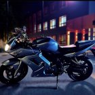 Intricate blue and gold custom motorcycle at night with illuminated buildings