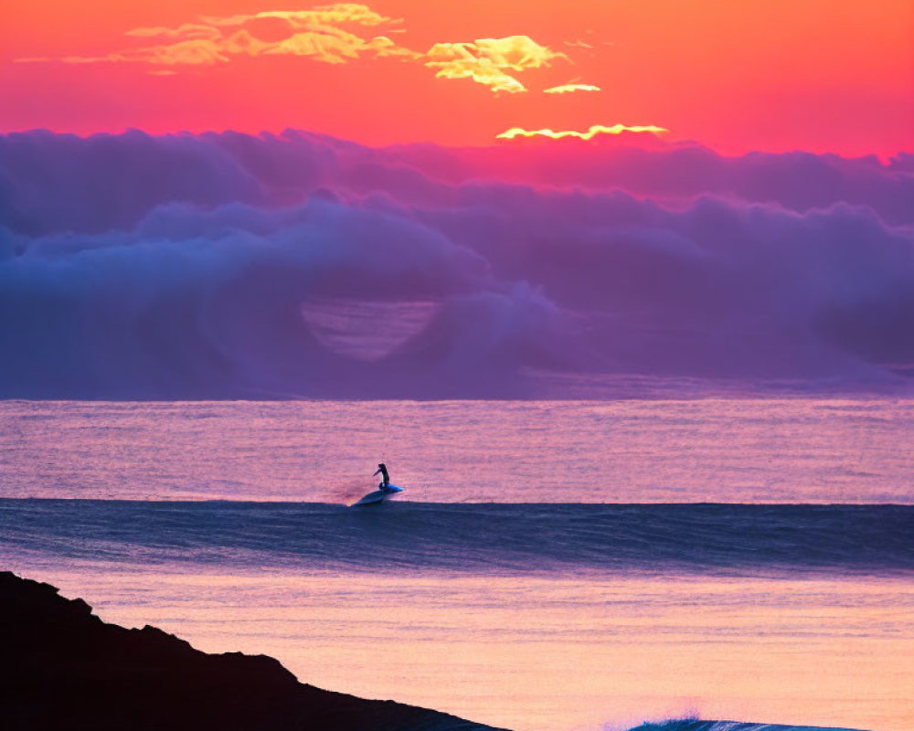 Surfer riding wave at sunrise with vibrant pink and orange skies