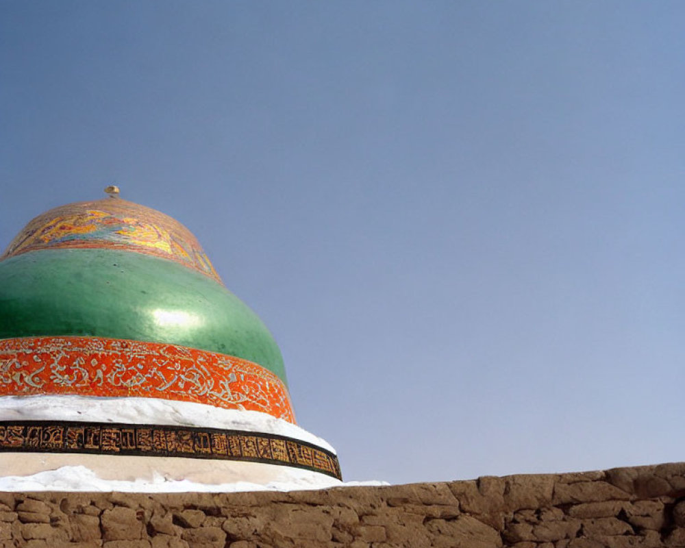 Green and Orange Patterned Dome Against Blue Sky with Snow-Covered Wall