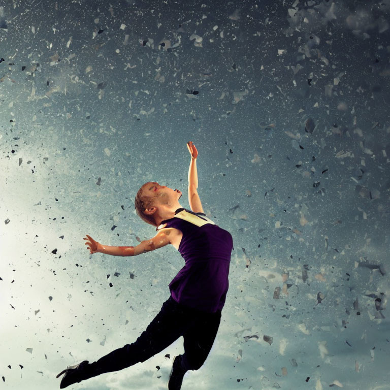 Graceful dancer leaping amid shattered fragments under stormy sky