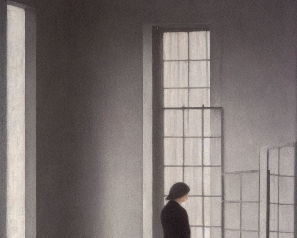 Solitary figure in room with tall windows casting shadow
