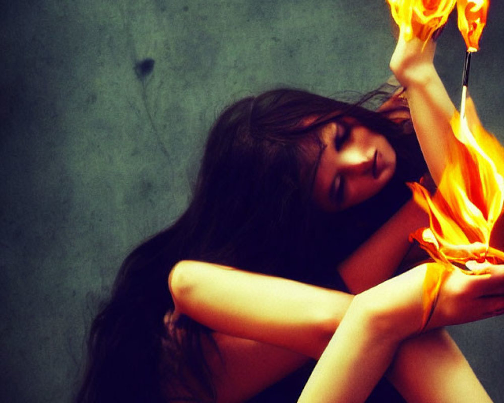 Woman Holding Flame Against Dark Textured Background