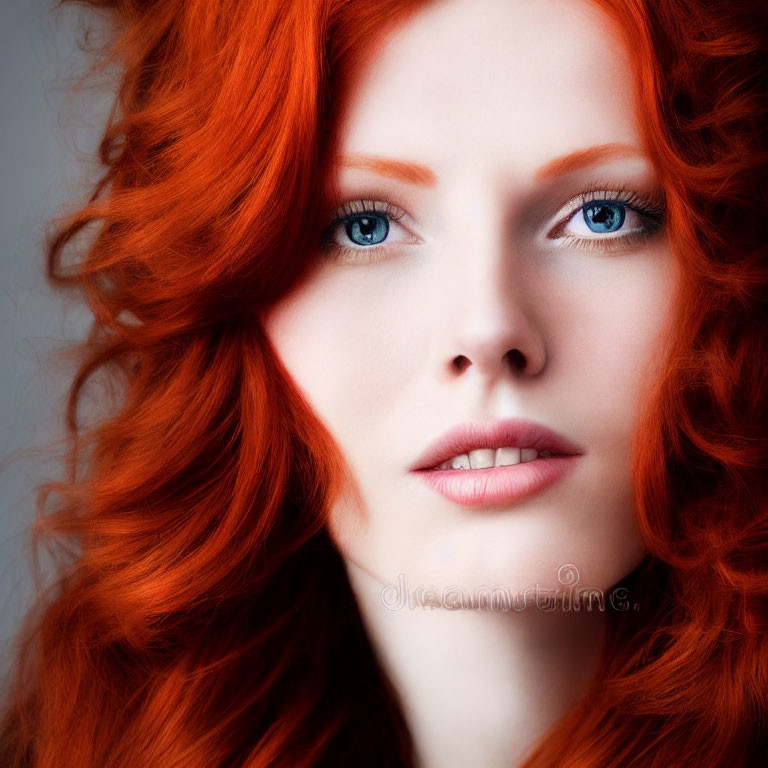 Portrait of woman with red hair, porcelain skin, and blue eyes.