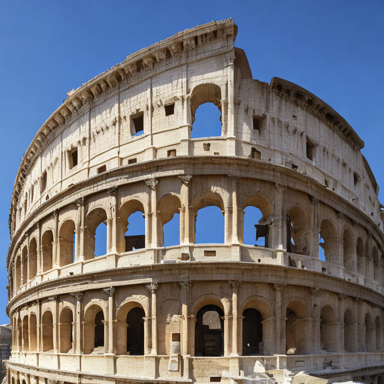 Daytime view of Ancient Roman Colosseum with arched exterior and clear blue sky