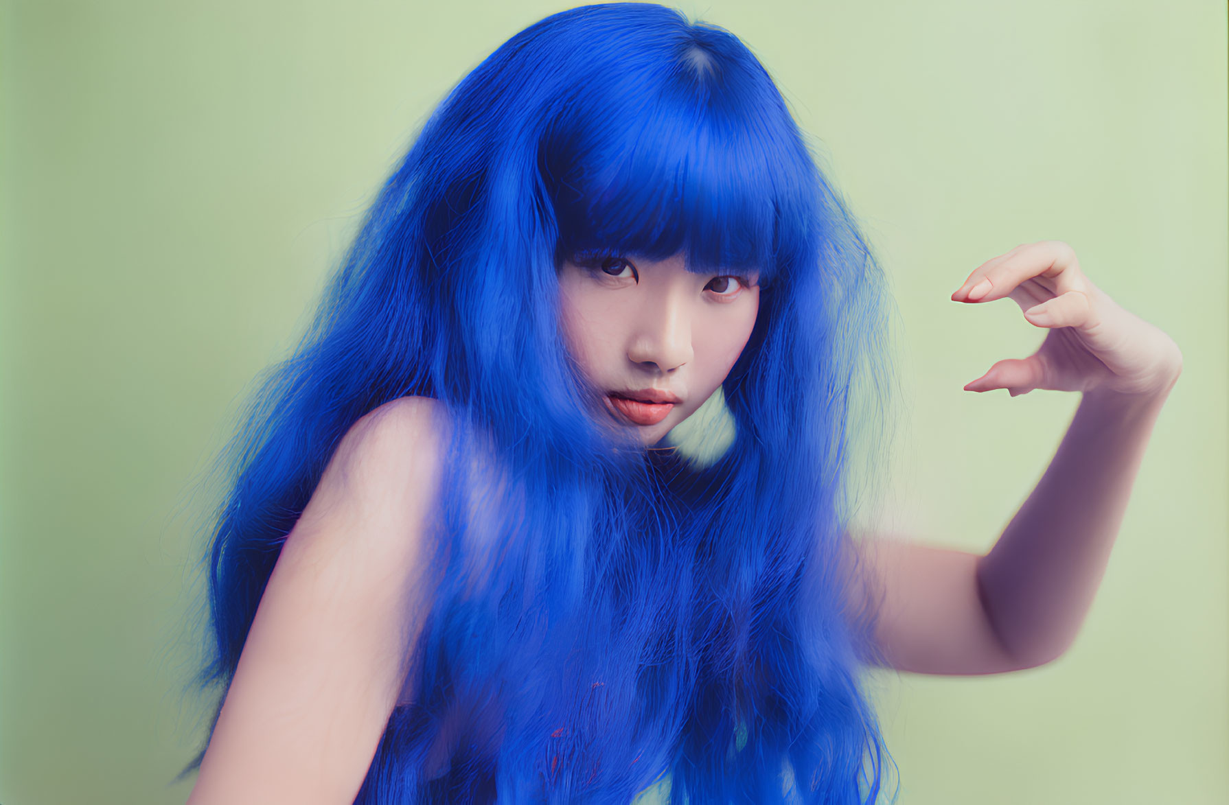 Vibrant Blue-Haired Person Posing Against Green Background
