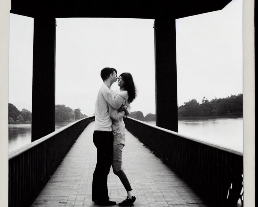 Couple Embraces on Bridge with Water Background in Monochrome Photo