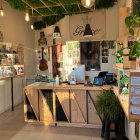 Contemporary dispensary interior with hanging plants, well-lit shelves, and circular cannabis leaf displays