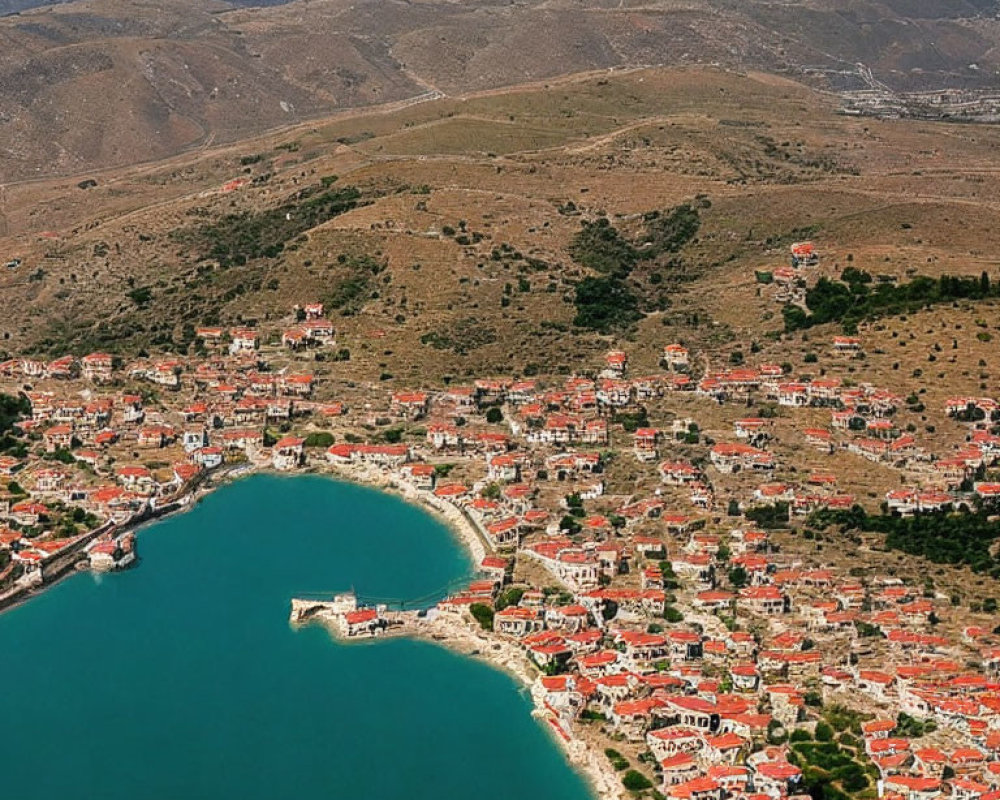 Coastal Town with Red-Roofed Buildings in Bay and Rolling Hills