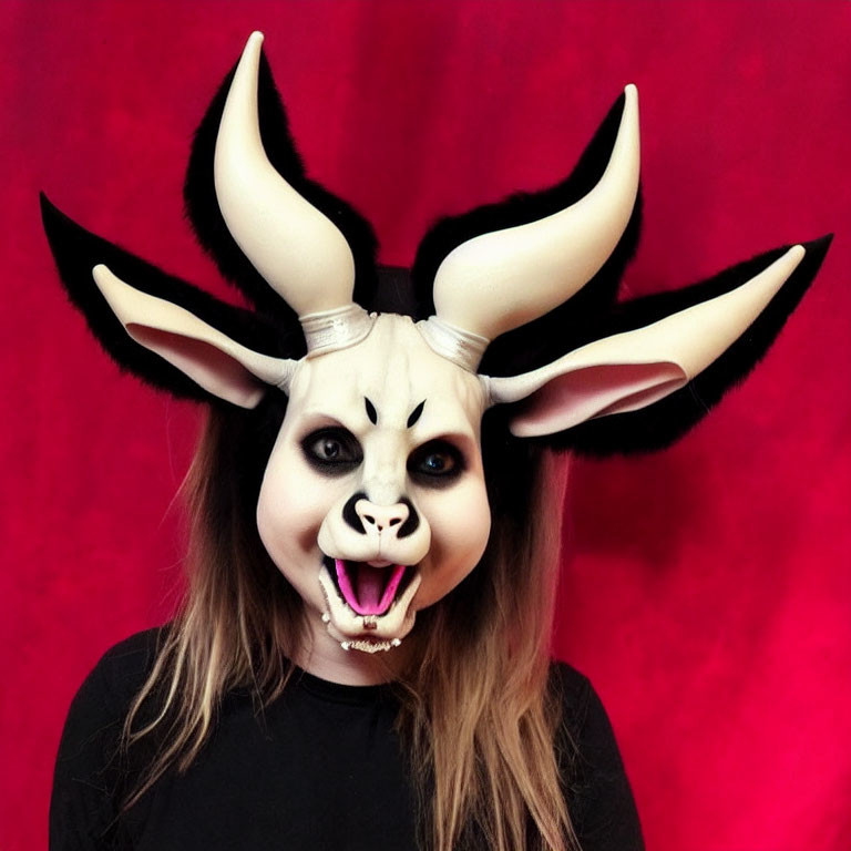 Person in Goat-Like Mask with Twisted Horns on Red Background