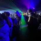 Neon green streaks illuminate dancers in dimly lit club