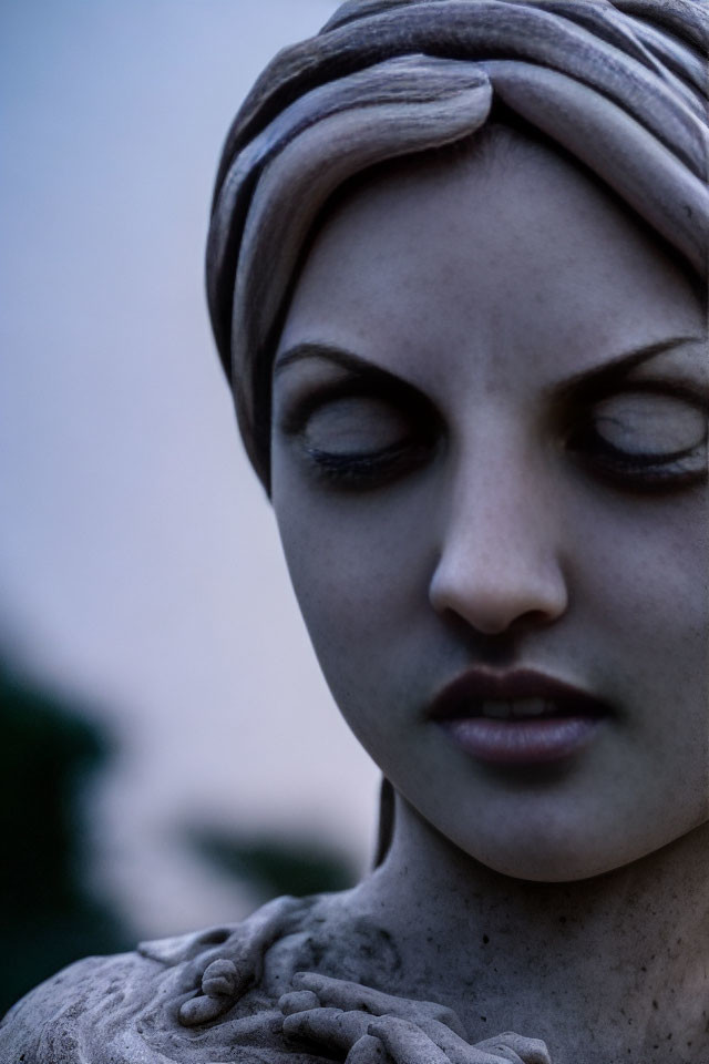Detailed statue of woman with headscarf in soft focus background