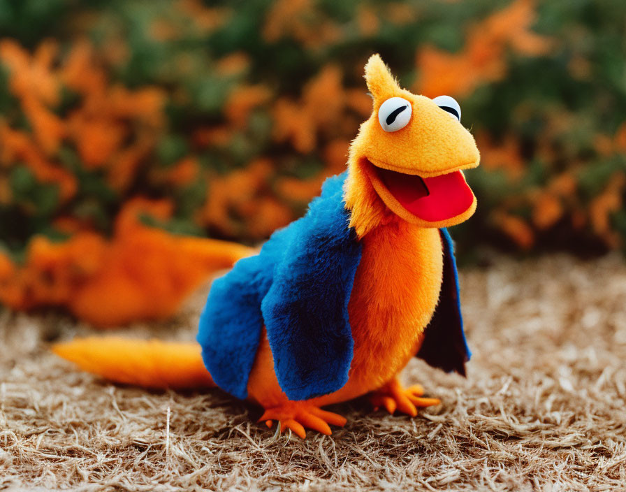 Colorful Bird Plush Toy with Orange and Blue Feathers on Grass Background