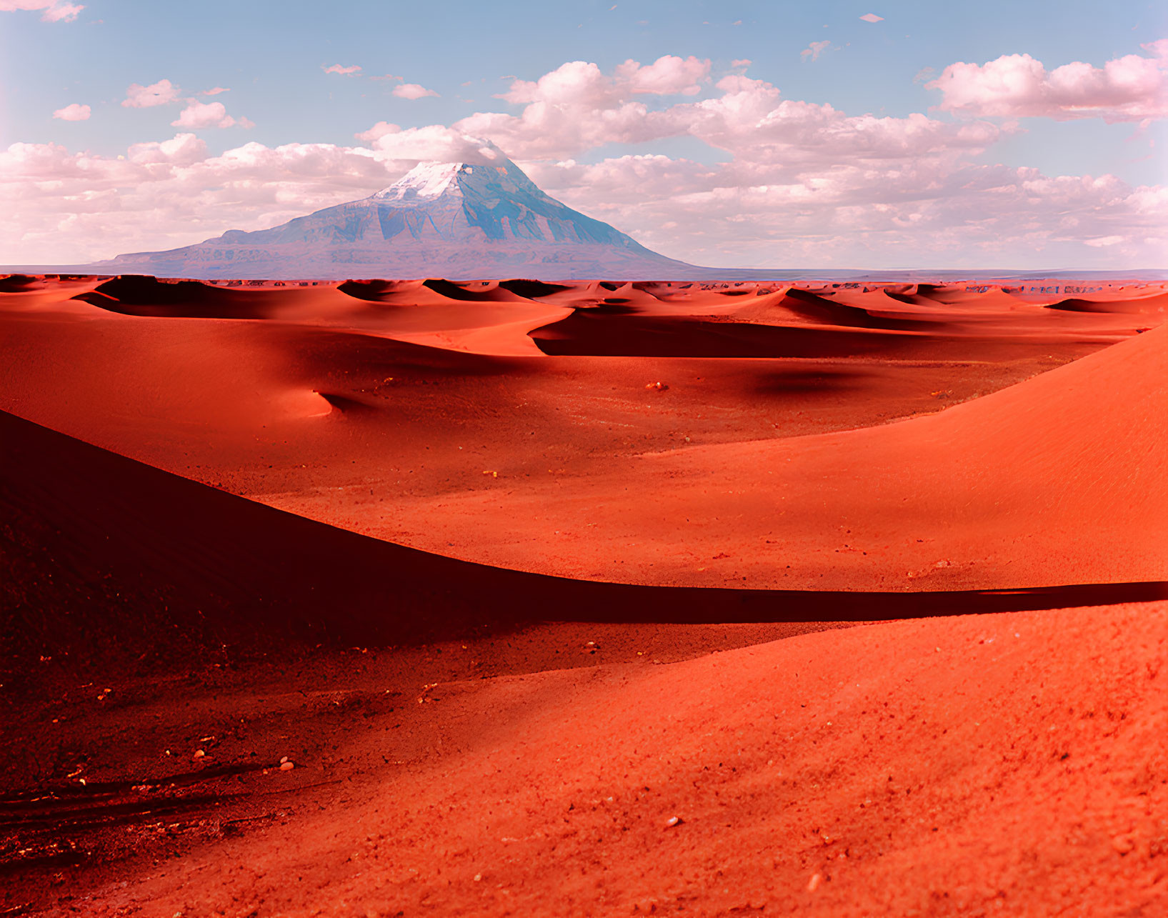 Scenic red sand desert with dunes and mountain landscape