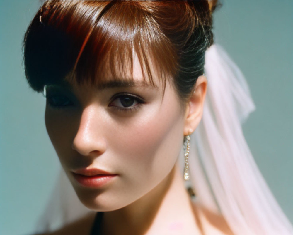 Portrait of woman with auburn hair and white veil, wearing earrings