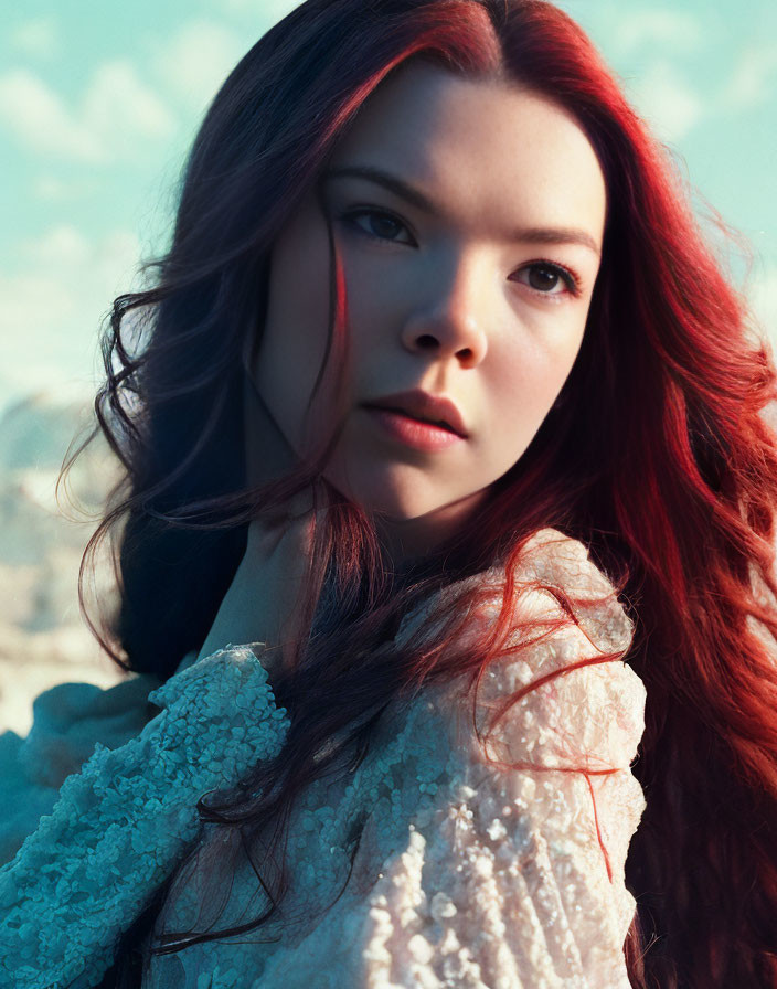 Red-haired woman in white lace top against sky-blue backdrop