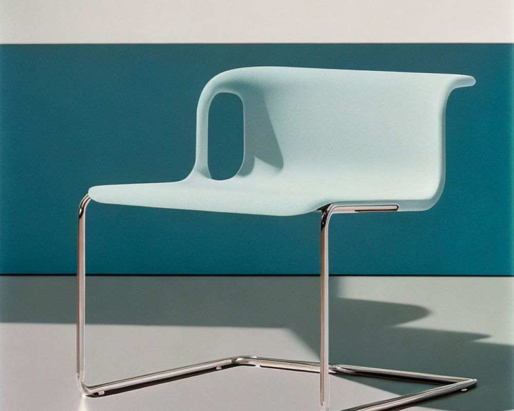 Turquoise Plastic Seat Chair on Chrome Base Against Blue Background