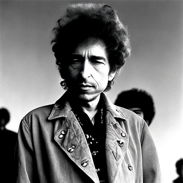 Monochrome portrait of man with curly hair in embellished jacket