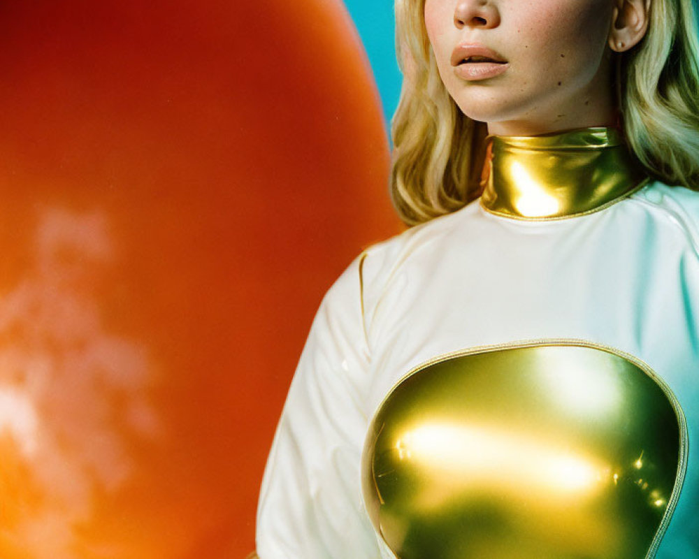 Futuristic woman in white and gold outfit with orange balloon in background