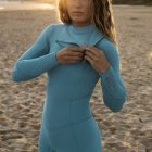 Woman in Tight Blue Bodysuit Stands in Field at Sunset