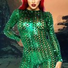 Red-haired person in futuristic green bodysuit with luminous details on bokeh light background