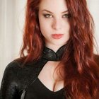 Red-haired person in black outfit with high collar and gloves