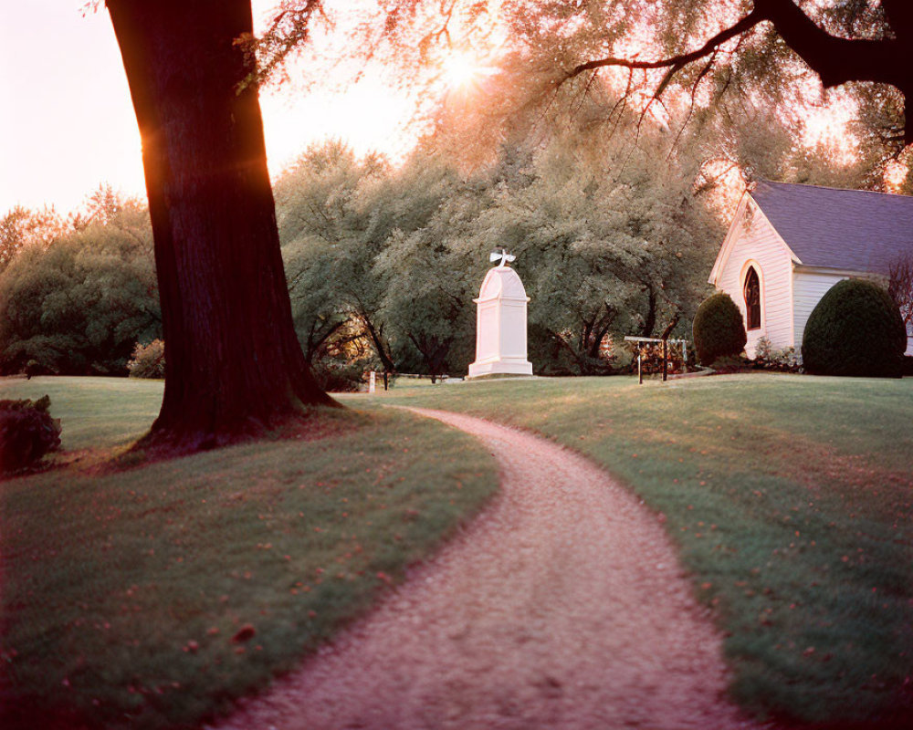 Scenic park path to chapel at sunset among golden trees