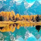 Vibrant autumn landscape: lake, colorful trees, cottages, mountains