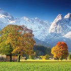 Scenic autumn mountain landscape with cozy cabin and grazing animals