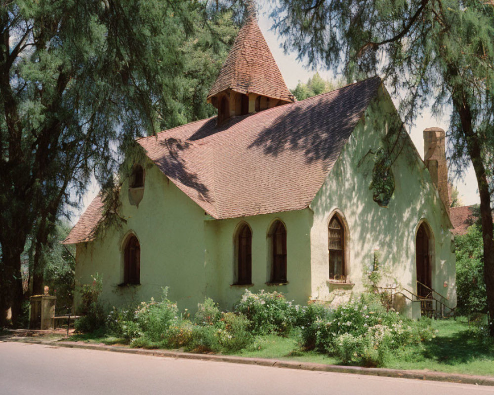 Old Church with Sloped Roof Surrounded by Trees Under Blue Sky