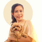 Woman with braided hair holding small dog in saintly aura.