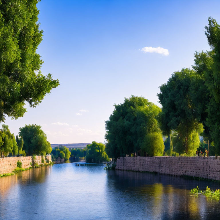Tranquil river scene with lush trees, blue sky, and stone embankment