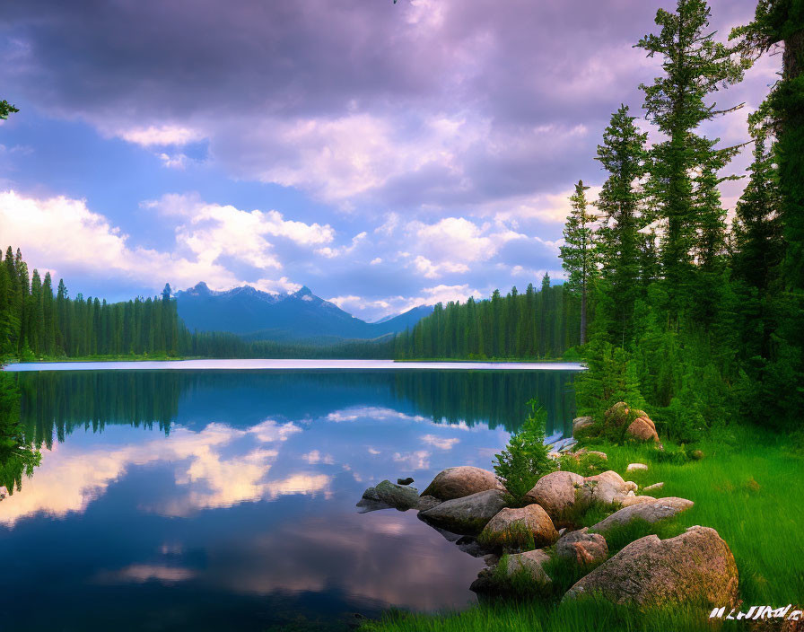 Scenic lake with mirrored trees, purple sky, and mountain backdrop