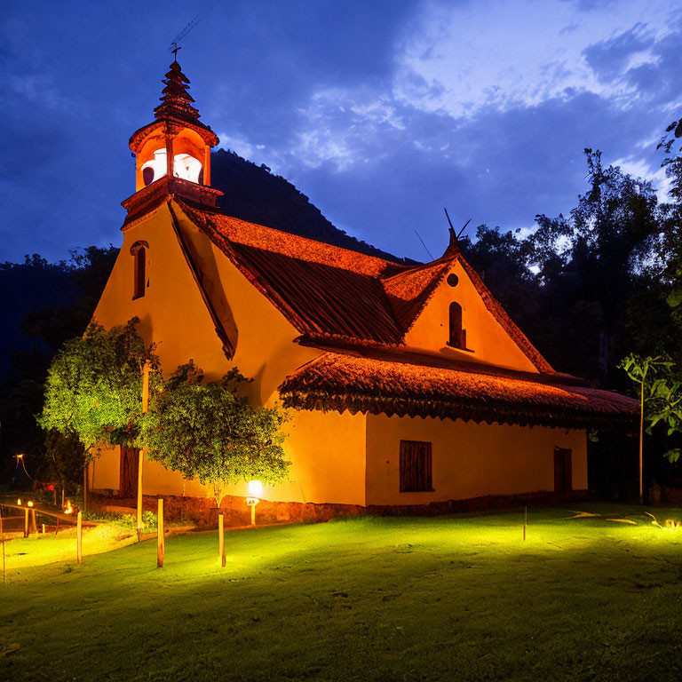 Rustic church with illuminated bell tower at twilight