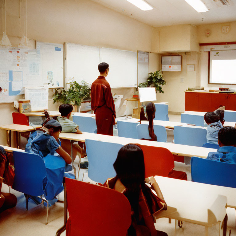 Classroom scene with students in blue chair-bags and teacher by computer and whiteboard