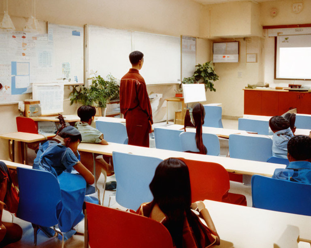 Classroom scene with students in blue chair-bags and teacher by computer and whiteboard