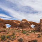 Iconic red sandstone arches under dramatic cloudy sky in Arches National Park