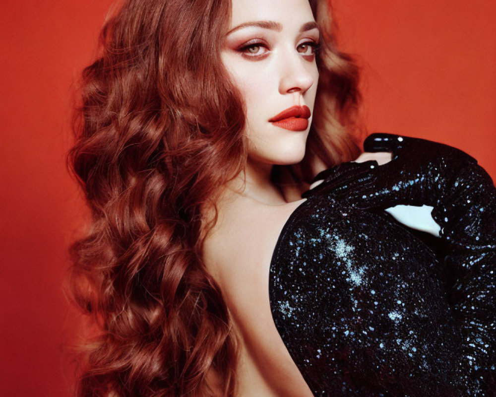 Auburn-Haired Woman in Black Sequined Outfit on Red Background
