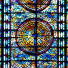 Vibrant stained-glass window with geometric patterns and circular design