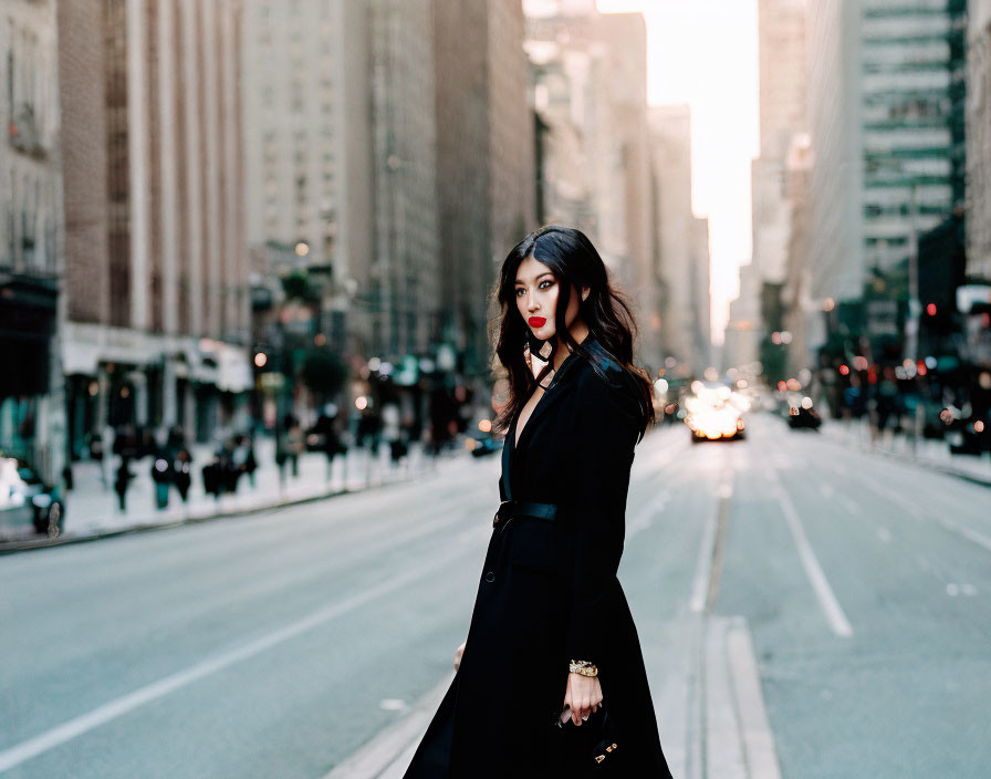 Woman in Black Coat Walking on City Street with Blurred Background