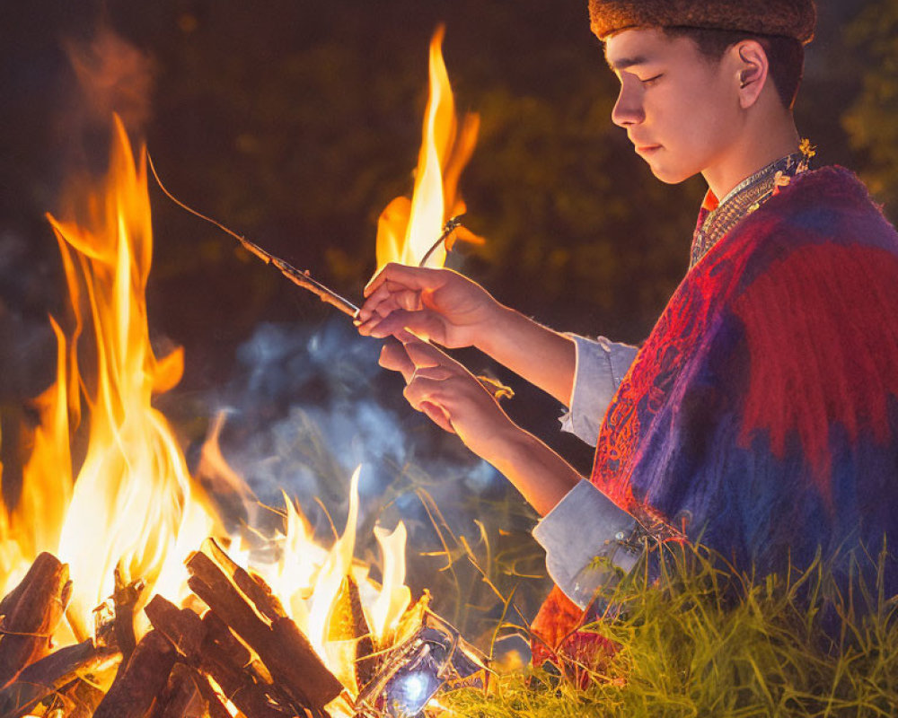 Person in traditional attire by campfire at night with fur hat holding stick