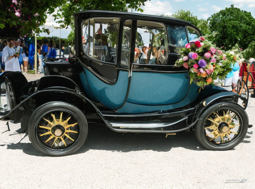 Vintage black and teal car with flowers displayed at outdoor event