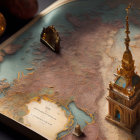 Detailed 3D vintage atlas with realistic topography and golden tower on dark background