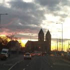 Silhouette of fairytale castle in sunset sky with flowers and street lamps