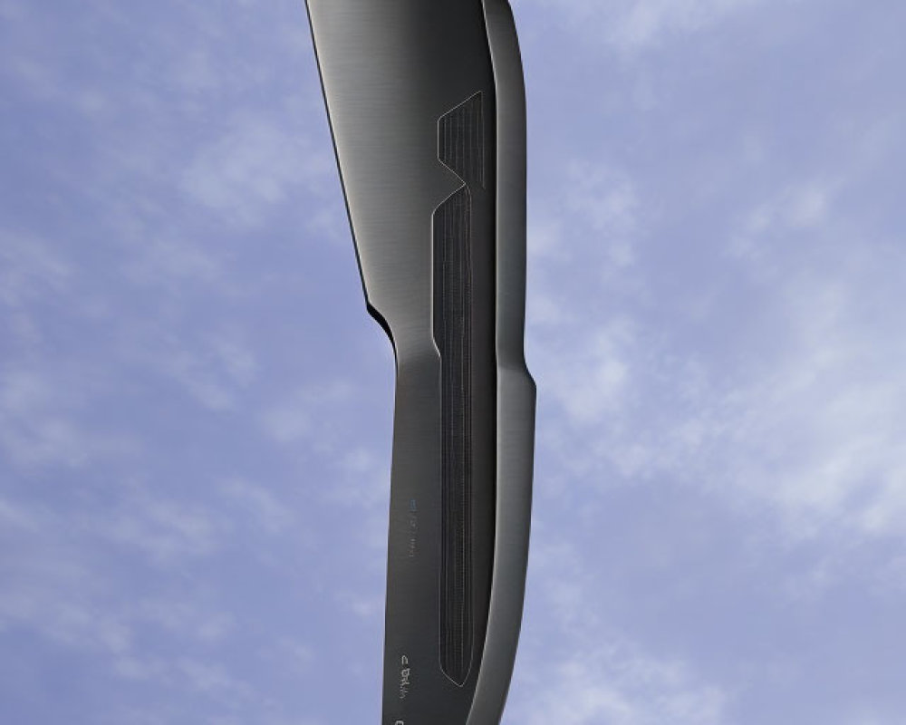Curved black blade knife on blue sky background