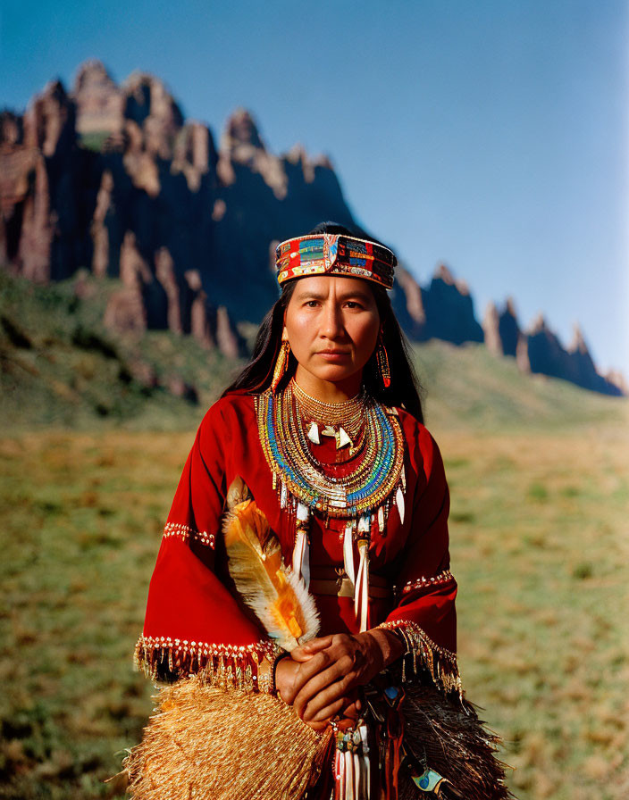 Native American in Traditional Dress Against Mountain Landscape