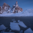 Twilight scene: Snowy peaks, shooting stars, frozen lake reflection