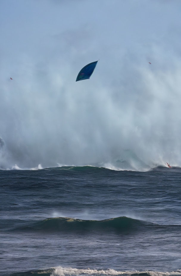 Windsurfing sail above turbulent ocean with foamy waves under cloudy sky